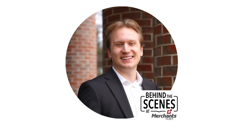 Smiling person in a suit stands by a brick wall; text says "Behind the Scenes at Merchants Fleet.
